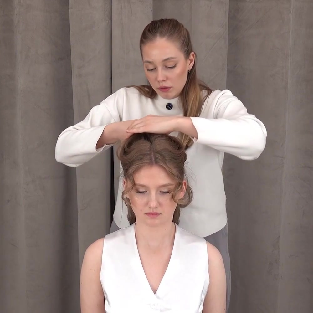 Instructor gathers the upper section while leaving the curled lower lengths loose