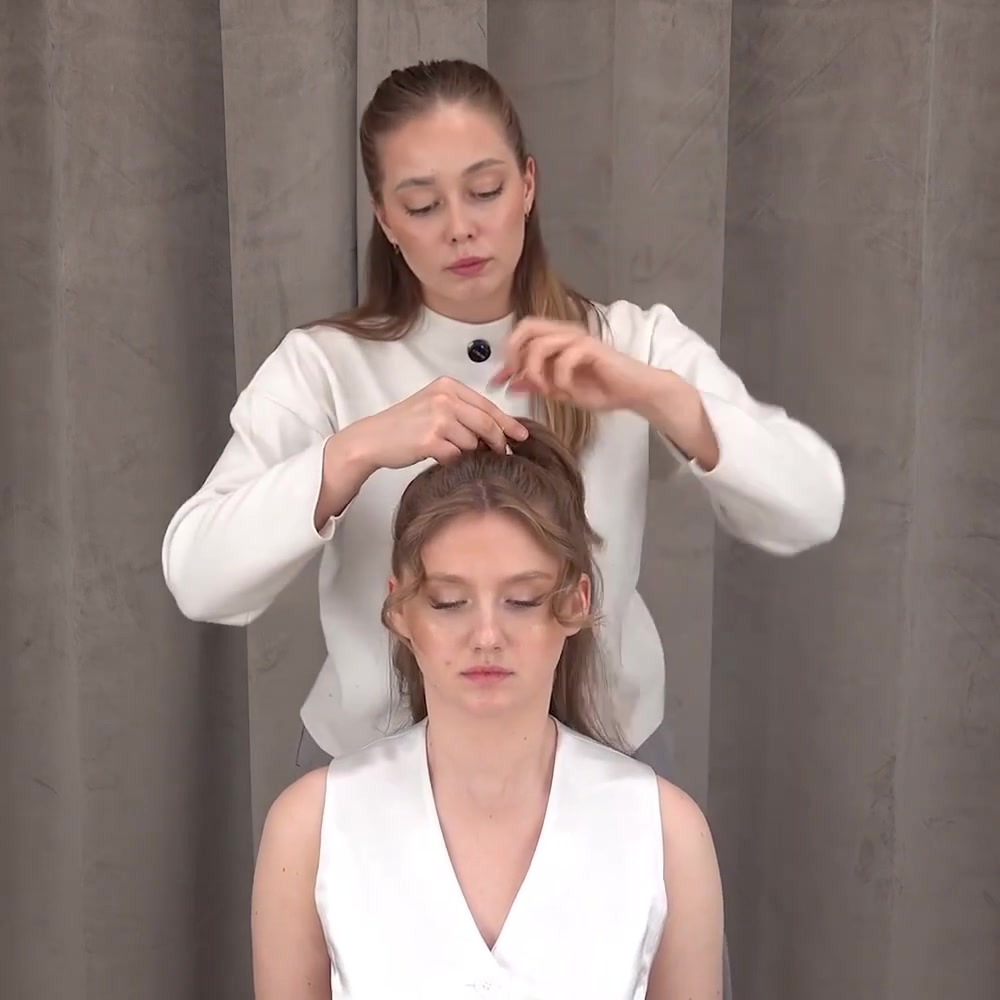 Instructor secures the gathered upper hair into a half ponytail