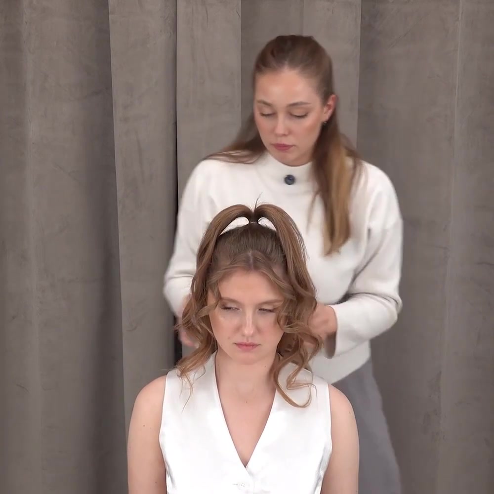 Instructor arranges the curled sections of the secured half ponytail