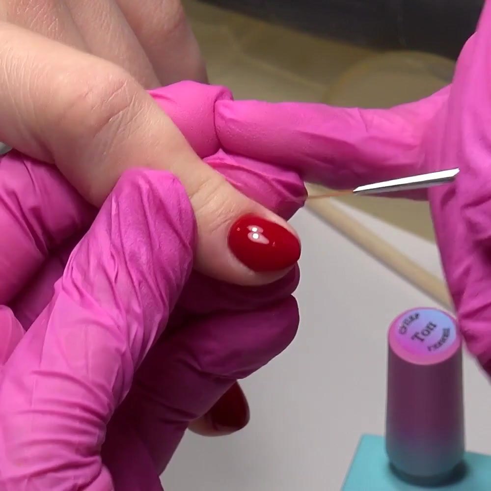 Se aplica una capa fina de top coat sobre el gel polish rojo curado
