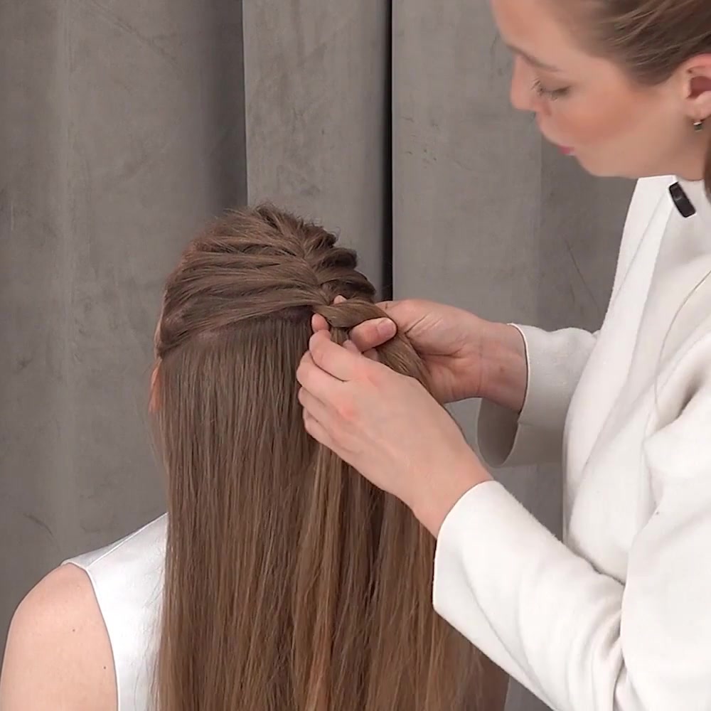 Ksenia keeps her fingers close to the growing braid for even control