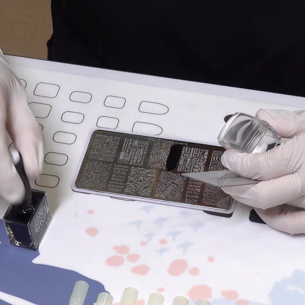 Black stamping polish covers the selected engraved pattern on the metal plate