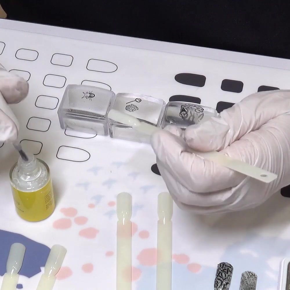 A very thin layer of air-dry foil glue is brushed onto a practice nail tip