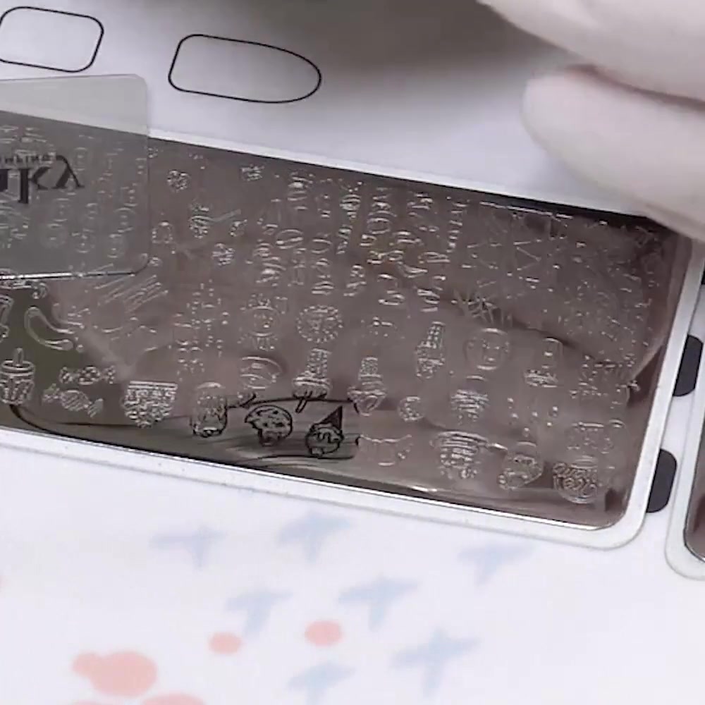 A clear silicone stamper picks up three black dessert outlines from the plate