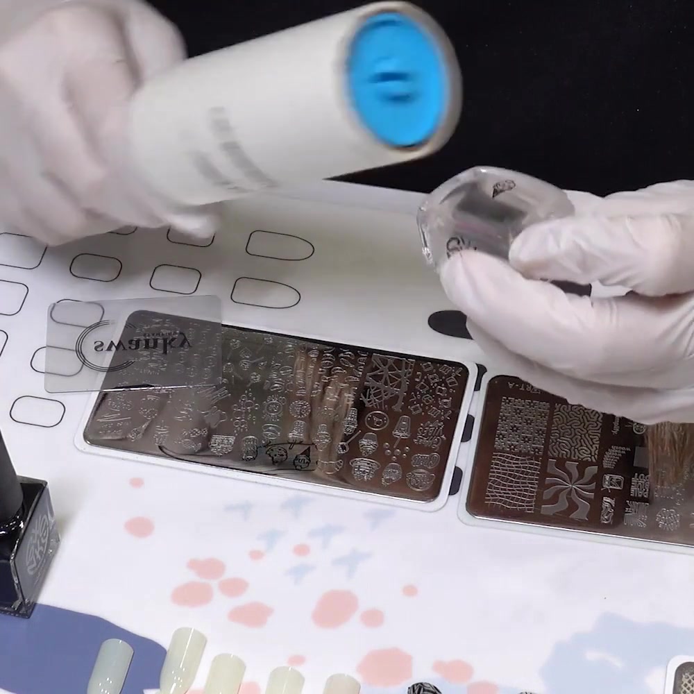 A lint roller removes unwanted polish beside a small stamped outline on a clear stamper