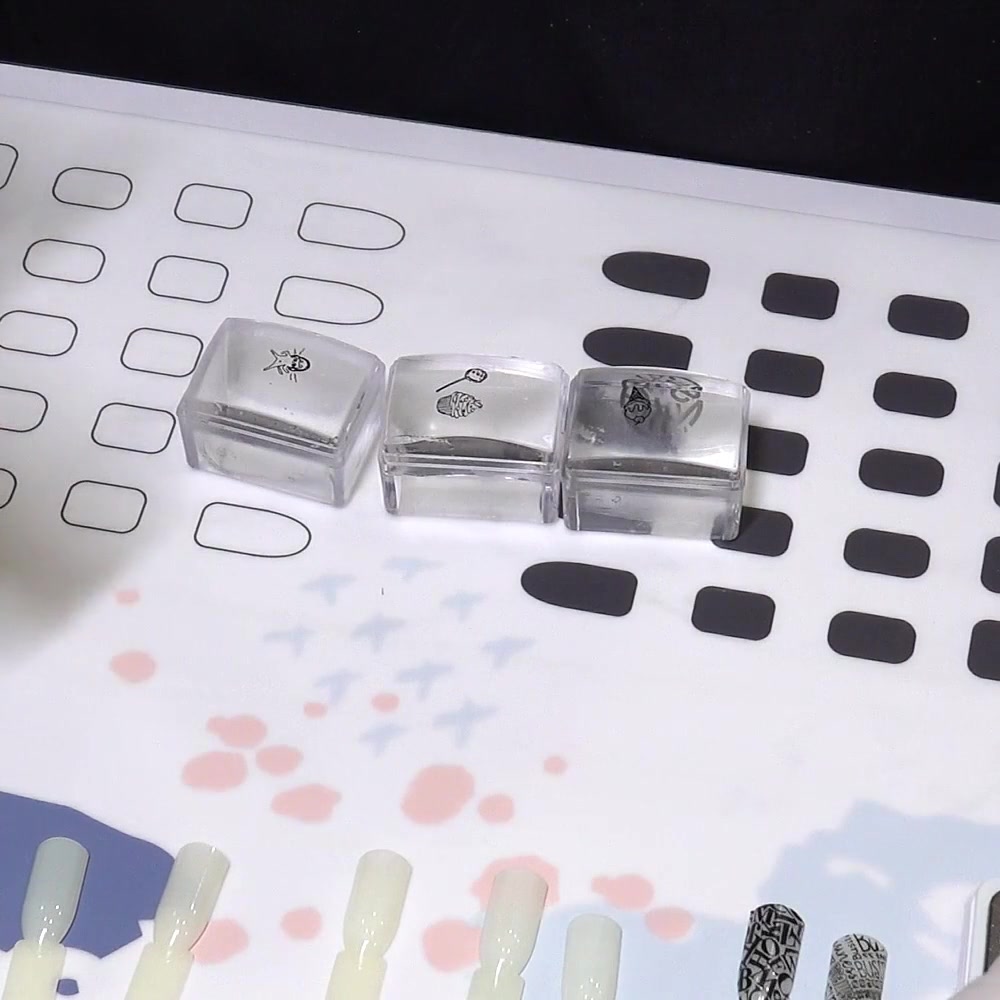 Three clear stampers hold black outlines while the designs dry