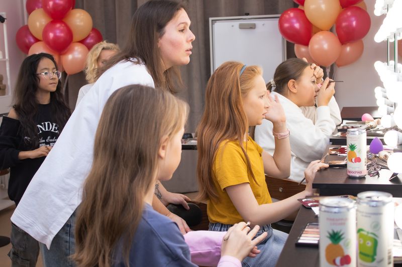 Teens learning makeup techniques at a beauty birthday party
