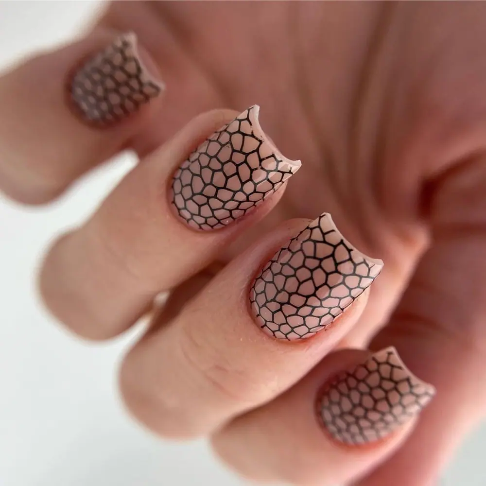 Black stamped patterns on a pale pink manicure from the Oh!Nice stamping course gallery